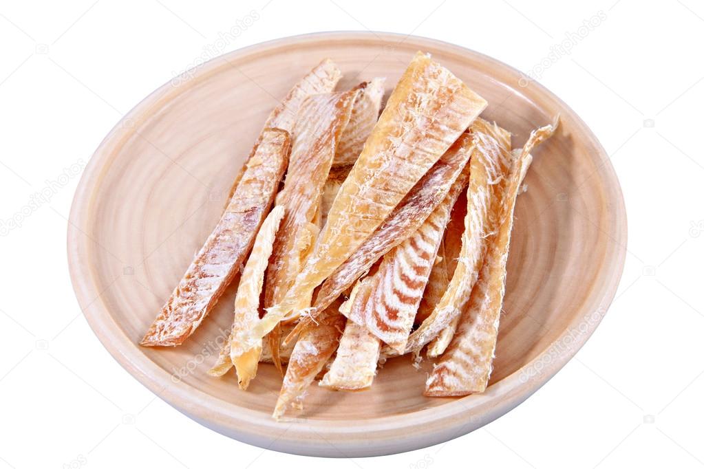 Slices of stockfish on plate made of wood, insulation image.
