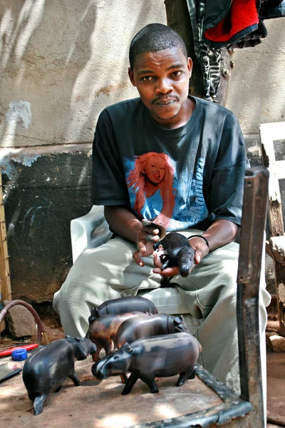 Young black African man, a wood carver, working art workshop. — Stock Photo, Image