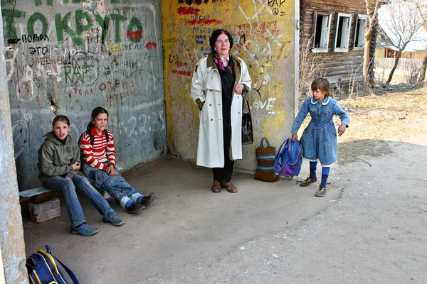 Russia, rural schoolgirls waiting transport at the bus stop — Stock Photo, Image