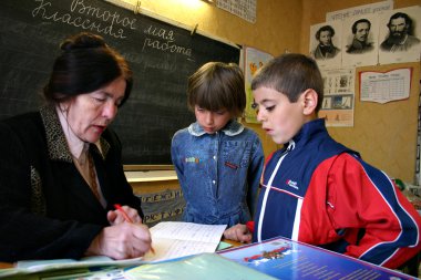 Children Pupils, Boy And Girl Look Like A School Teacher Checks Homework. clipart