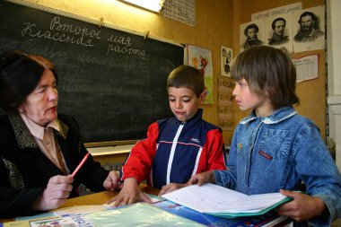 Rus köy okulunda sınıf, bir öğretmen öğrencilerle iletişim kurar..