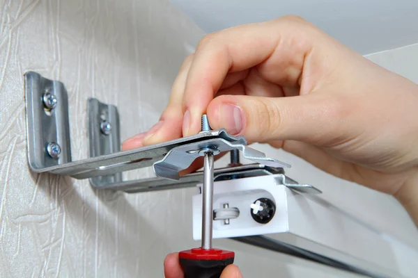 Vertical blinds mounting brackets, hand with a screw close up — Stock Photo, Image