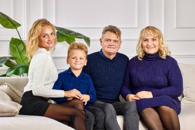 Kafkas ailesi oturma odasında portre için poz veriyor..