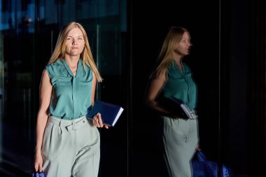 Kadın ofis çalışanı, iş merkezinin yakınındaki notlar için not defteri tutuyor..