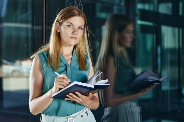 Gerente femenina escribe notas cerca del centro de negocios en notebook. — Foto de Stock