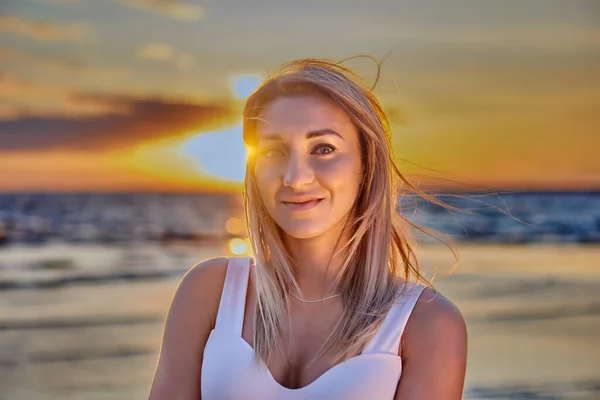 Retrato de mulher branca sorridente na praia durante o pôr do sol. — Fotografia de Stock