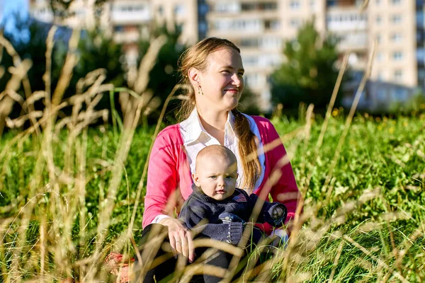 Happy european woman walks with infant in public park. — Stock Photo, Image