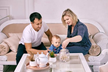 Bebeklerin aileleri dinlenme odasında kanepede oturur..