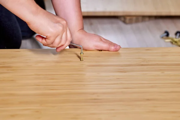 El ensamblador instala muebles de paquete plano utilizando tornillos y herramientas. — Foto de Stock