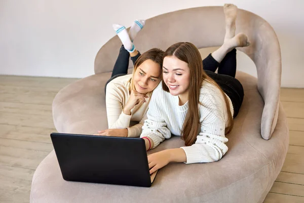 Casal feminino no sofá está conversando com amigos com laptop. — Fotografia de Stock