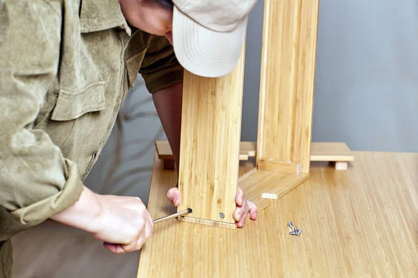 Montage von Flachpackmöbeln durch Heimwerker mit Schraubenzieher. — Stockfoto