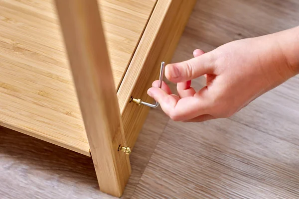 Handyman is assembling flat pack furniture using screws and tool. — Stock Photo, Image
