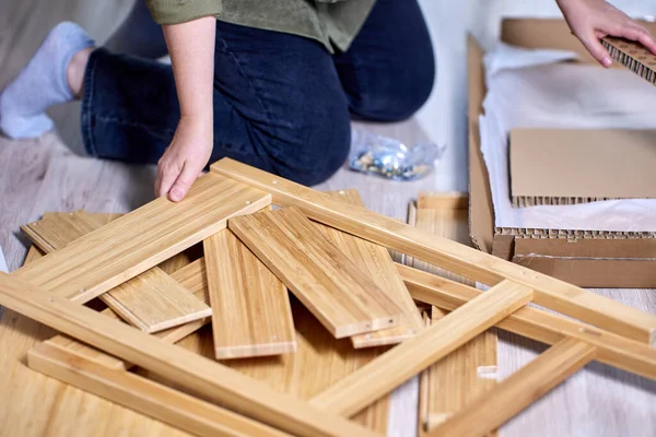 Мастер собирает мебель из плоской упаковки в квартире. — стоковое фото