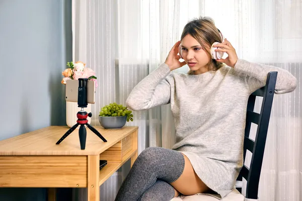 Жінка робить відеоблог за допомогою штатива та навушників . — стокове фото