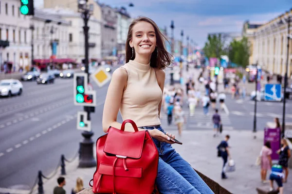 Gelukkige vrouw zit op drukke straat met verkeer. — Stockfoto