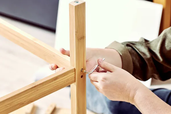 Handyman está montando mesa com a ajuda de chave allen. — Fotografia de Stock