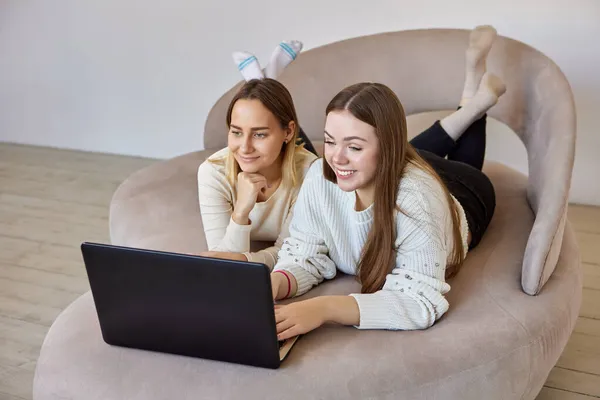 Amigos do sexo feminino assistir filmes no laptop no salão. — Fotografia de Stock