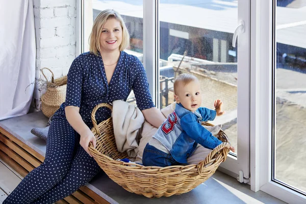 Femme heureuse avec tout-petit sur le rebord de la fenêtre à la maison. — Photo