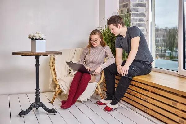 Achats en ligne à l'aide d'un ordinateur portable, jeune couple choisit des meubles dans un nouvel appartement. — Photo