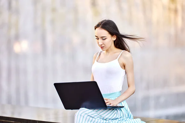 Електронне навчання або телемутінг за допомогою ноутбука, підключеного до Інтернету, молода жінка робить віддалену роботу під час відвідування публічного парку.. — стокове фото