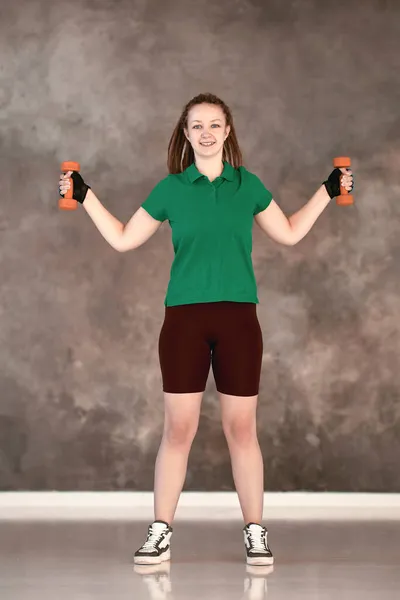 28-jarige vrouw traint met halters in sportstudio. — Stockfoto