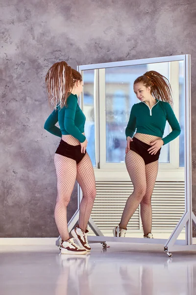 Specchio mobile da palestra in studio di danza, la donna misura visivamente il loro grasso corporeo. — Foto Stock