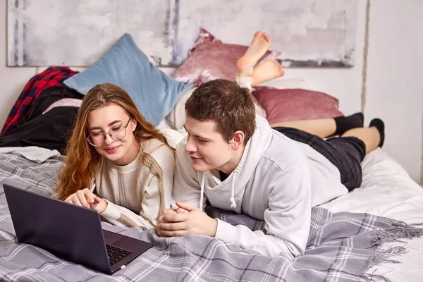 Familie is online winkelen terwijl ze op bed liggen in de slaapkamer. — Stockfoto