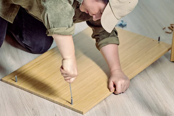 Diy montaje de muebles de paquete plano, mujer madura atornillar clavija. — Foto de Stock