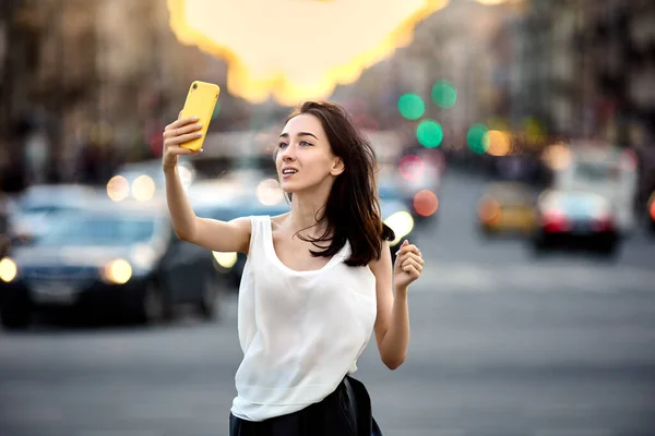 Kobieta robi selfie przy użyciu poręczny w St Petersburgu na ulicy. — Zdjęcie stockowe