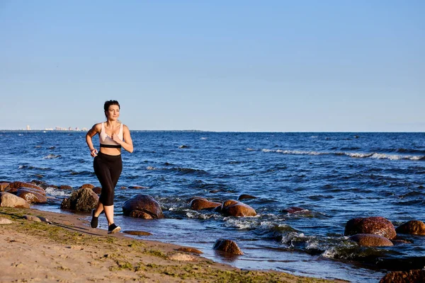 海辺の近くを走っている女性による朝の運動. — ストック写真