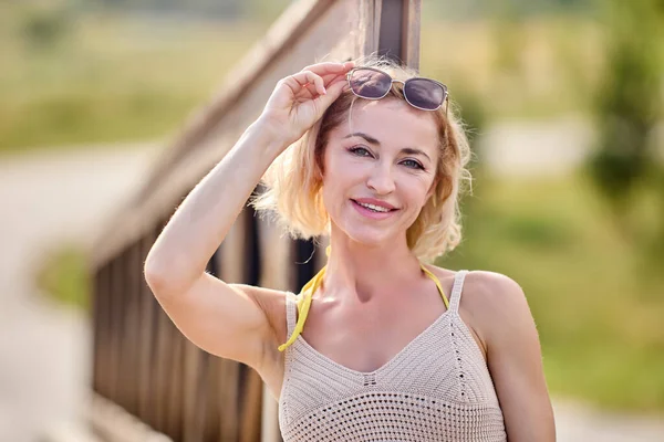 Medelålders lycklig kvinna står ute på sommardagen. — Stockfoto