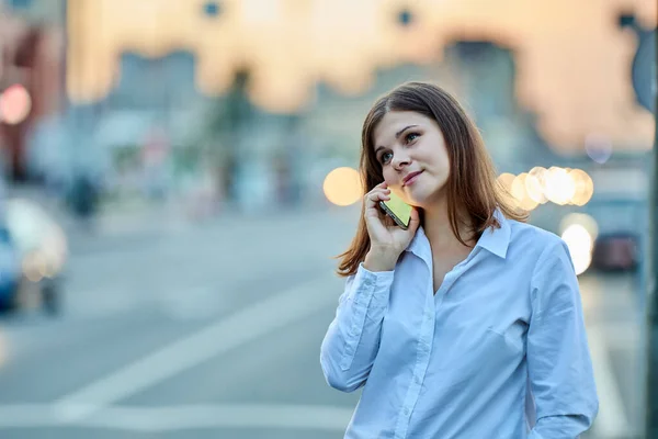 Jeune femme parle par pratique sur la rue de la circulation. — Photo