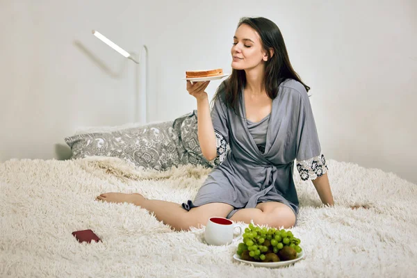Ungesundes Essen als Frühstück für schlanke Frau im Bett. — Stockfoto