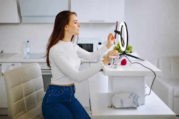 Beauty blogger utilizza la luce anulare con supporto del telefono cellulare durante lo streaming in diretta a casa. Immagini Stock Royalty Free