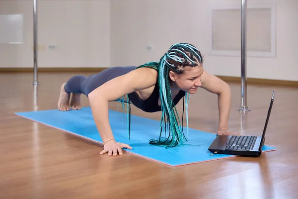 Aulas de fitness online usando laptop para mulher que está na prancha. — Fotografia de Stock