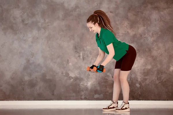 Женщина делает упражнения с гантелями в спортзале. — стоковое фото
