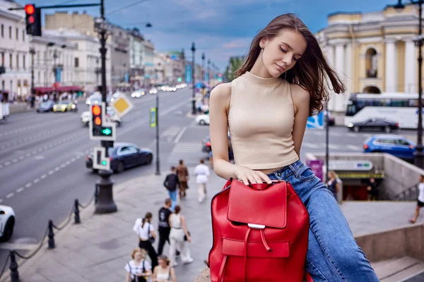 Kalabalık şehir caddesinde kırmızı deri çanta taşıyan bir kadın.. — Stok fotoğraf