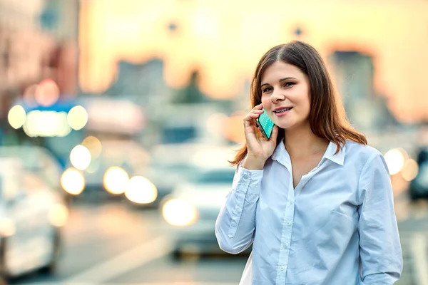 Kvinna ringer för taxi på city street med trafik med hjälp av smartphone. Royaltyfria Stockfoton