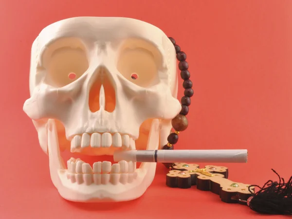 Human skull, cross, cigarette. — Stock Photo, Image