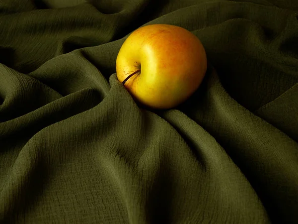 Яблуко Серед Складок Зеленої Тканини — стокове фото