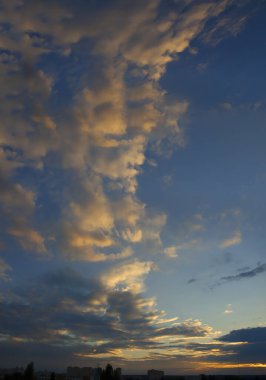 Batan güneşin ışınları bulutları aydınlatır.