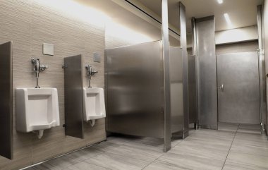 Seramik pisuarlı banyo ve ayrı bölmeler.