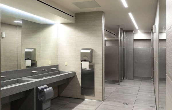 Seramik lavabolu banyo, ayna ve ayrı bölmeler.