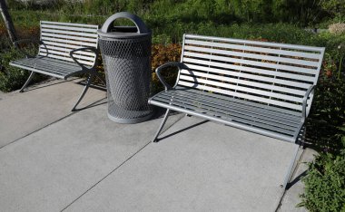 Parkta iki bank ve bir çöp kutusu.