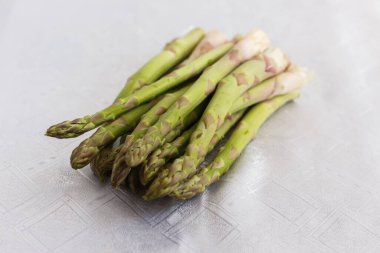 Beyaz masa örtüsü üzerinde kuşkonmaz.