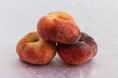 Şeftali piramidi beyaz bir masa örtüsü üzerinde