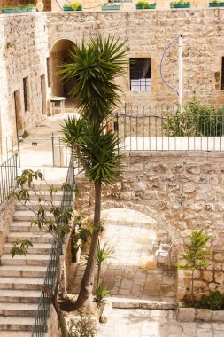 Kudüs 'teki Haç Manastırı' nın içinde merdivenleri ve kemeri olan bir avlu.