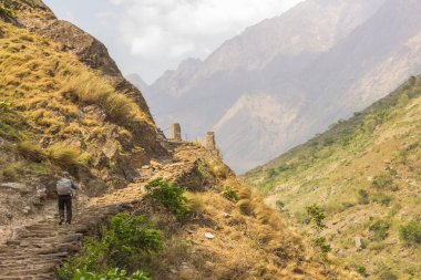 Manaslu bölgesinde dağ yolunda yürüyen bir adam merdiven şeklinde.