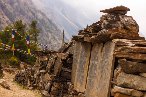 Manaslu bölgesindeki Himalayalar 'daki patika boyunca dua taşları duvarı.