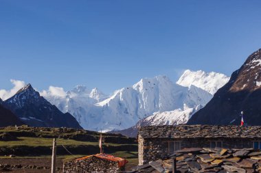 Himalayalar 'daki karlı dağların arka planına karşı evler